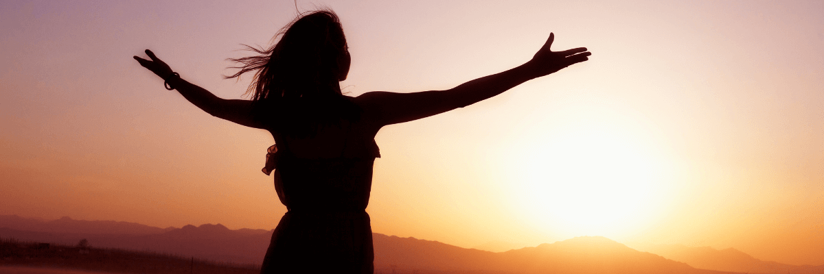 frau arme weit ausgebreitet im sonnenaufgang